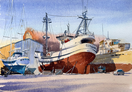 Shipyard with fishing boats docked and workers doing repairs at Port Townsend Shipwright and Boatyard